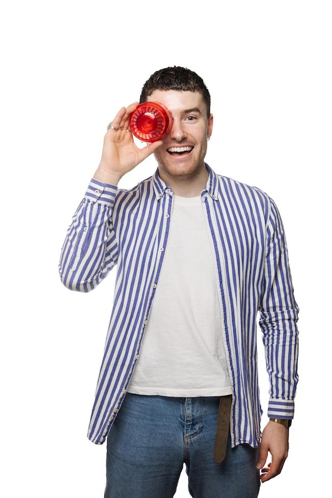 smiling male holding a fire alarm against his eye